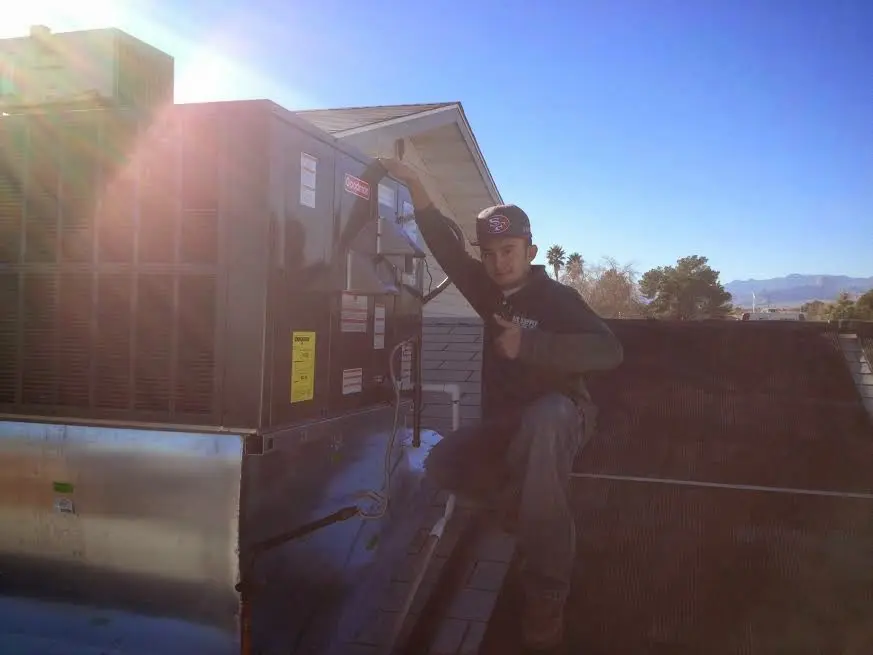 HVAC technician performing Boiler Repair on a rooftop unit in Marlin
